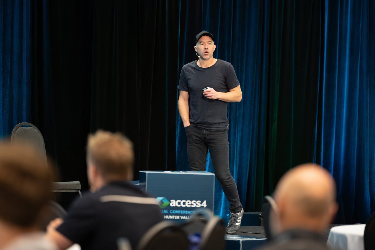 Daniel Anderson presenting on stage at the Access4 annual conference in the Hunter Valley
